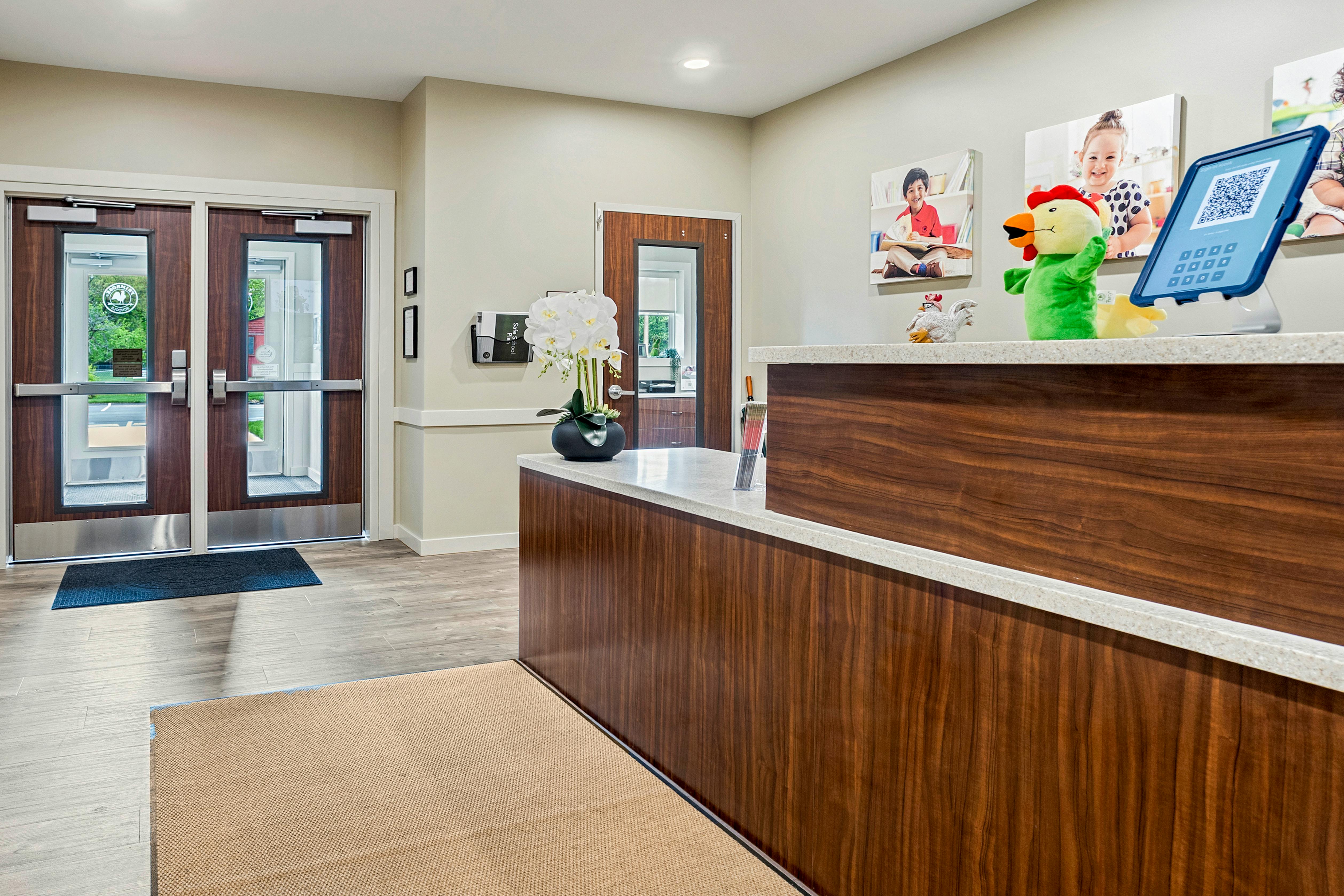 Reception desk with plush toys, tablet, and entrance doors