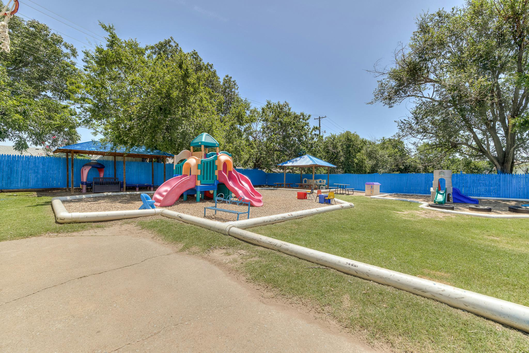 Playground with slides, sand, and grass
