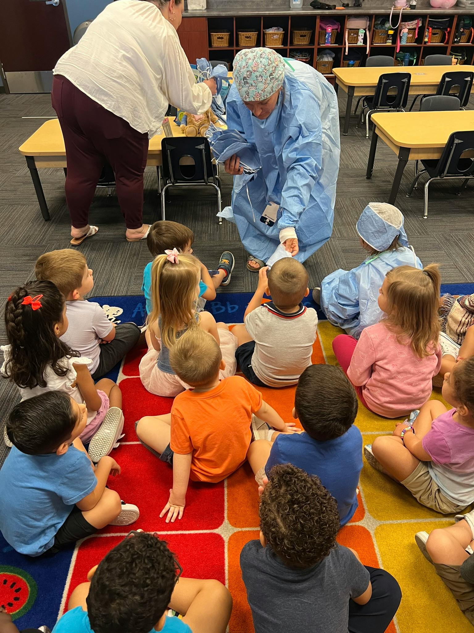 Person in scrubs showing children a bandaged arm