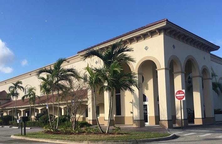 Building with arched entrance and palm trees