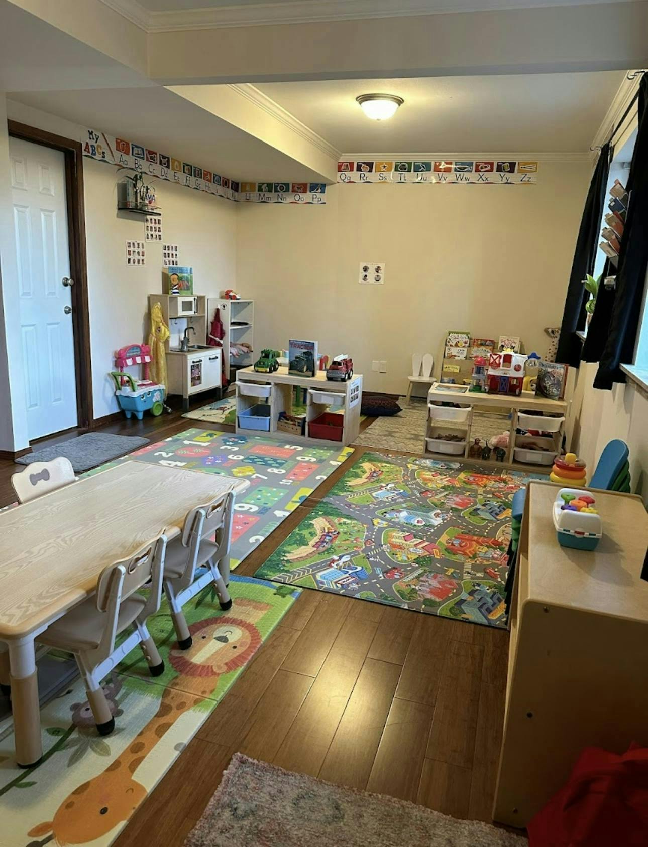 Playroom with small tables, chairs, and colorful playmats