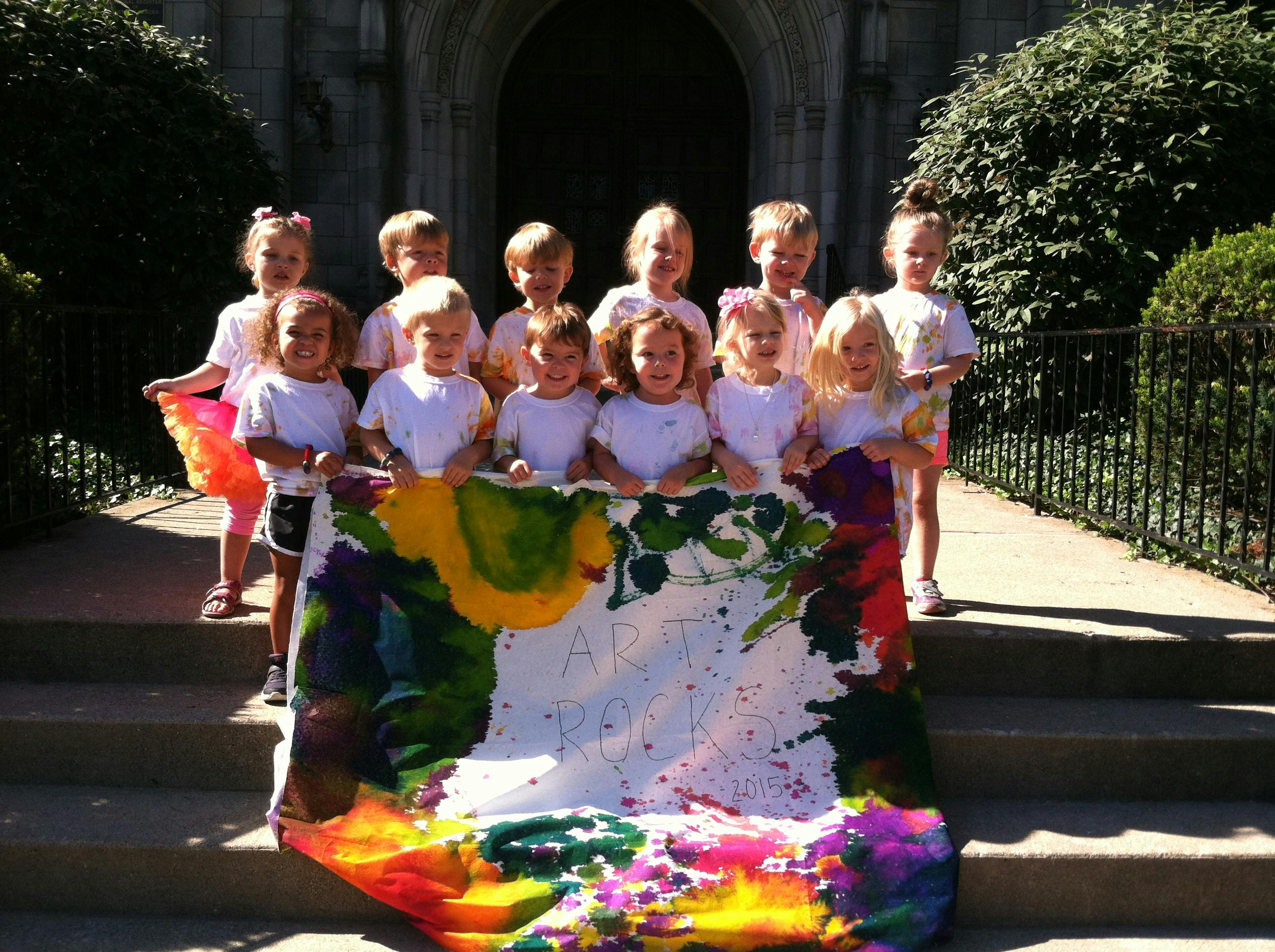 Group of children holding a colorful painted banner