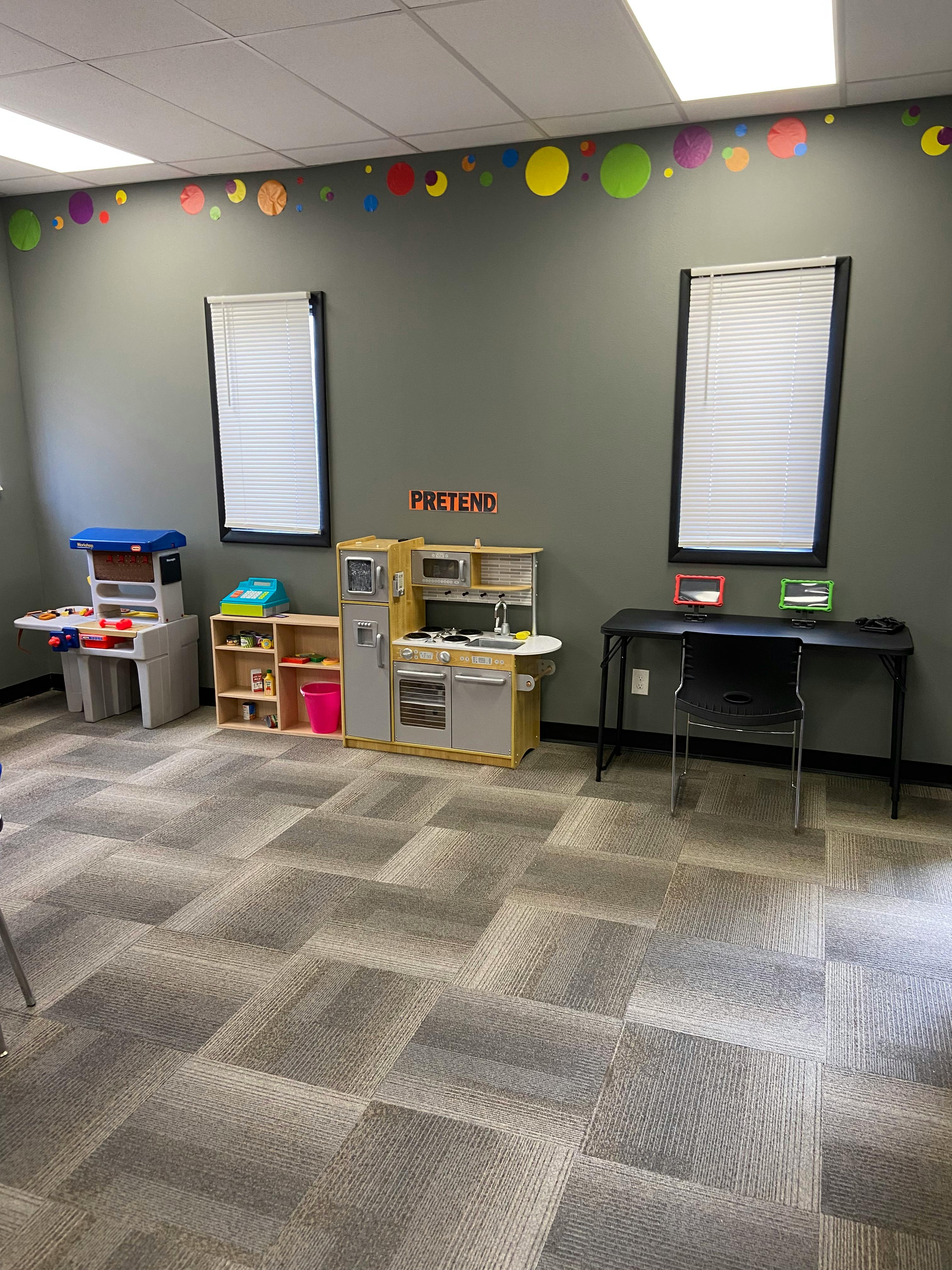Playroom with toy kitchen, workbench, and desk with chair