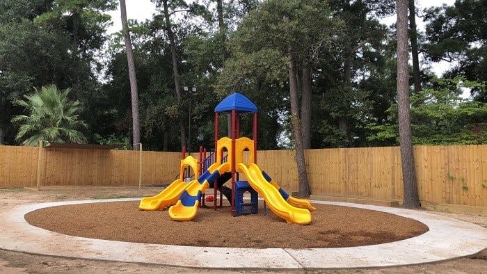 Playground with yellow and blue slides and climbing structure