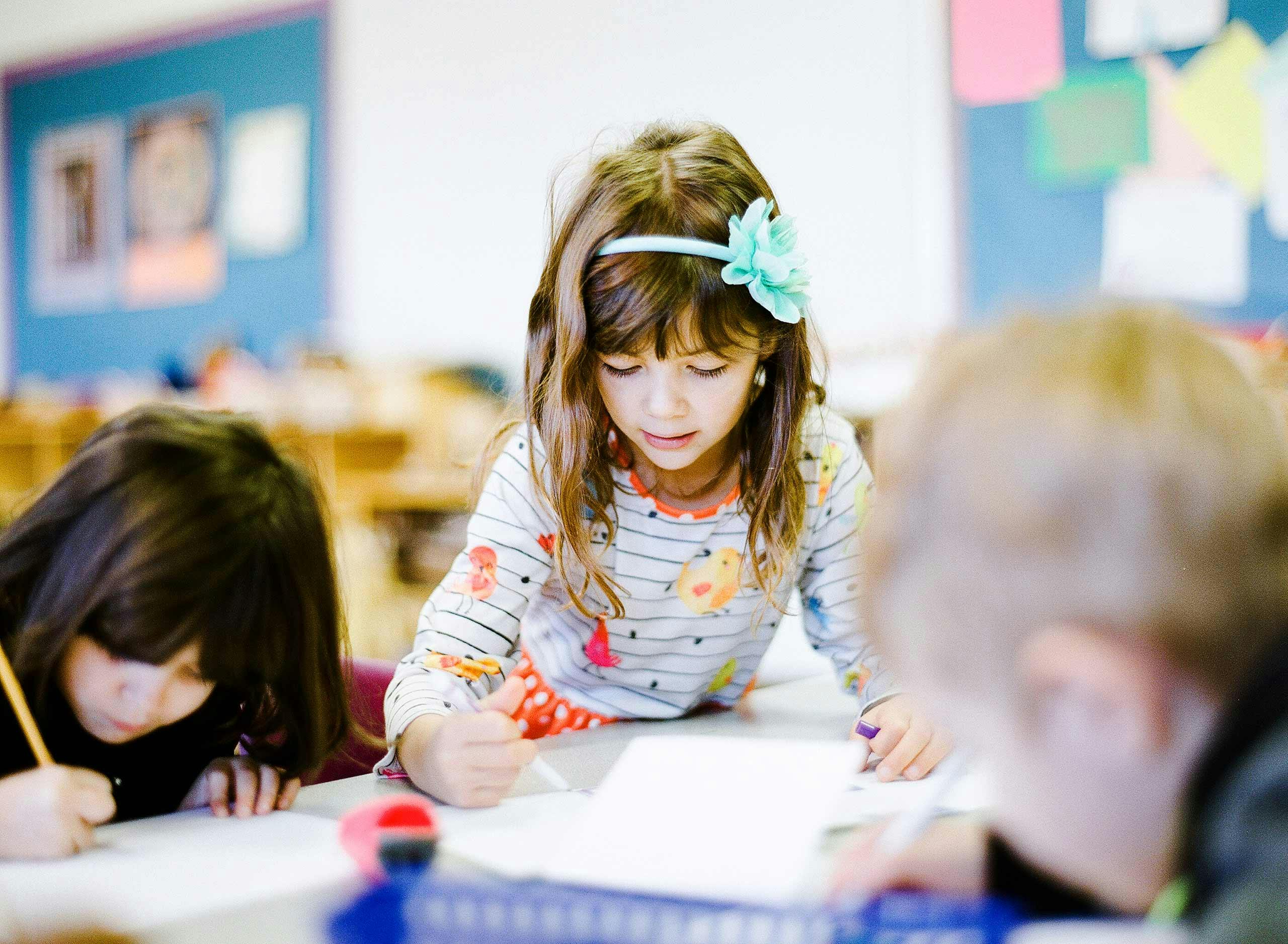 Children drawing at a table in a classroom