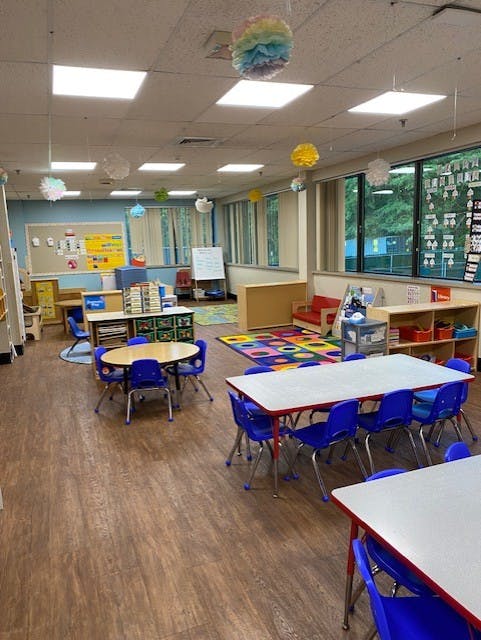 Empty classroom with small tables and chairs, colorful decorations