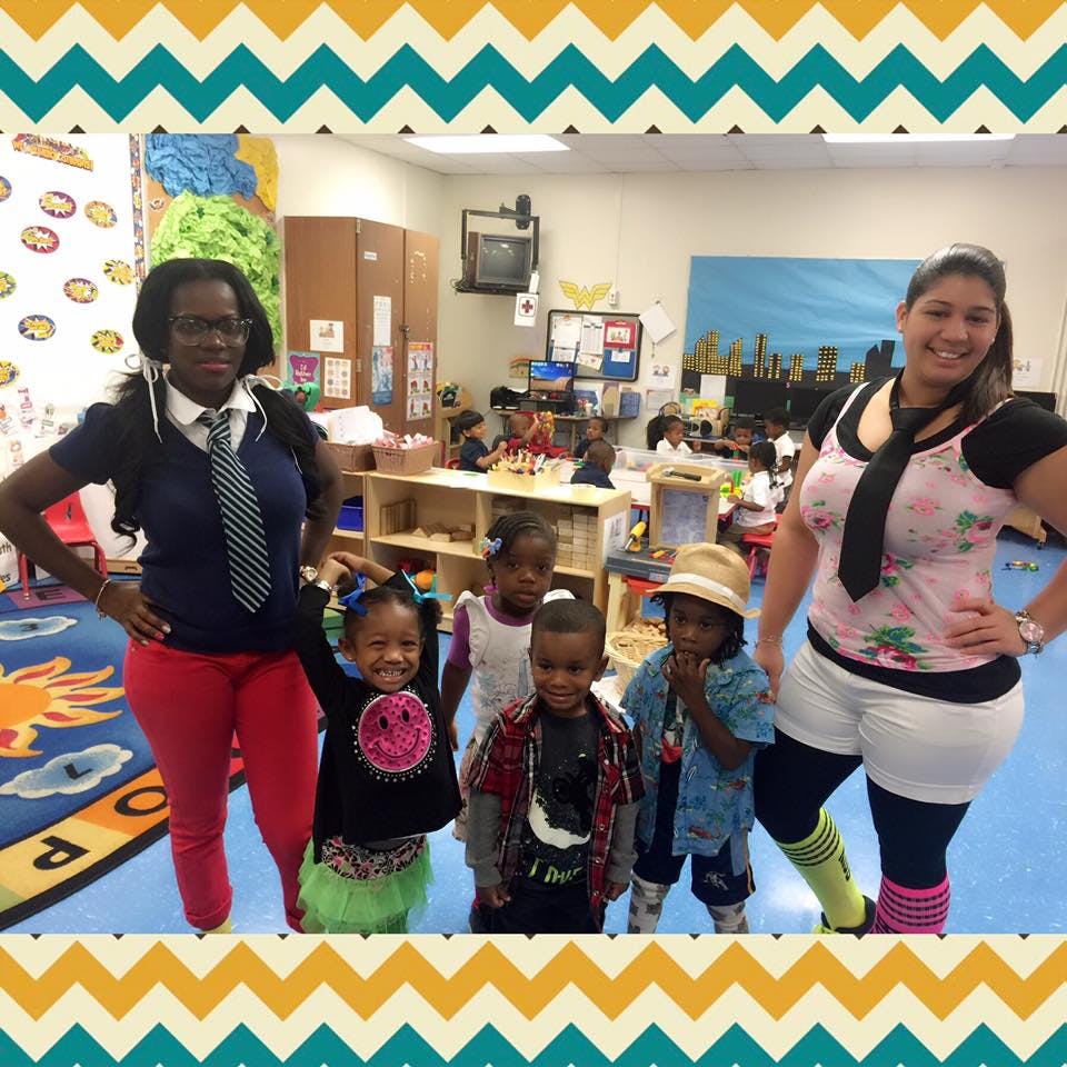 Two people and four children posing in a classroom