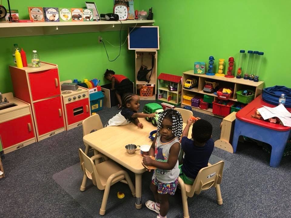 Children playing at a table in a classroom