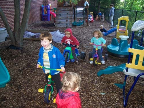 Children riding tricycles on a playground