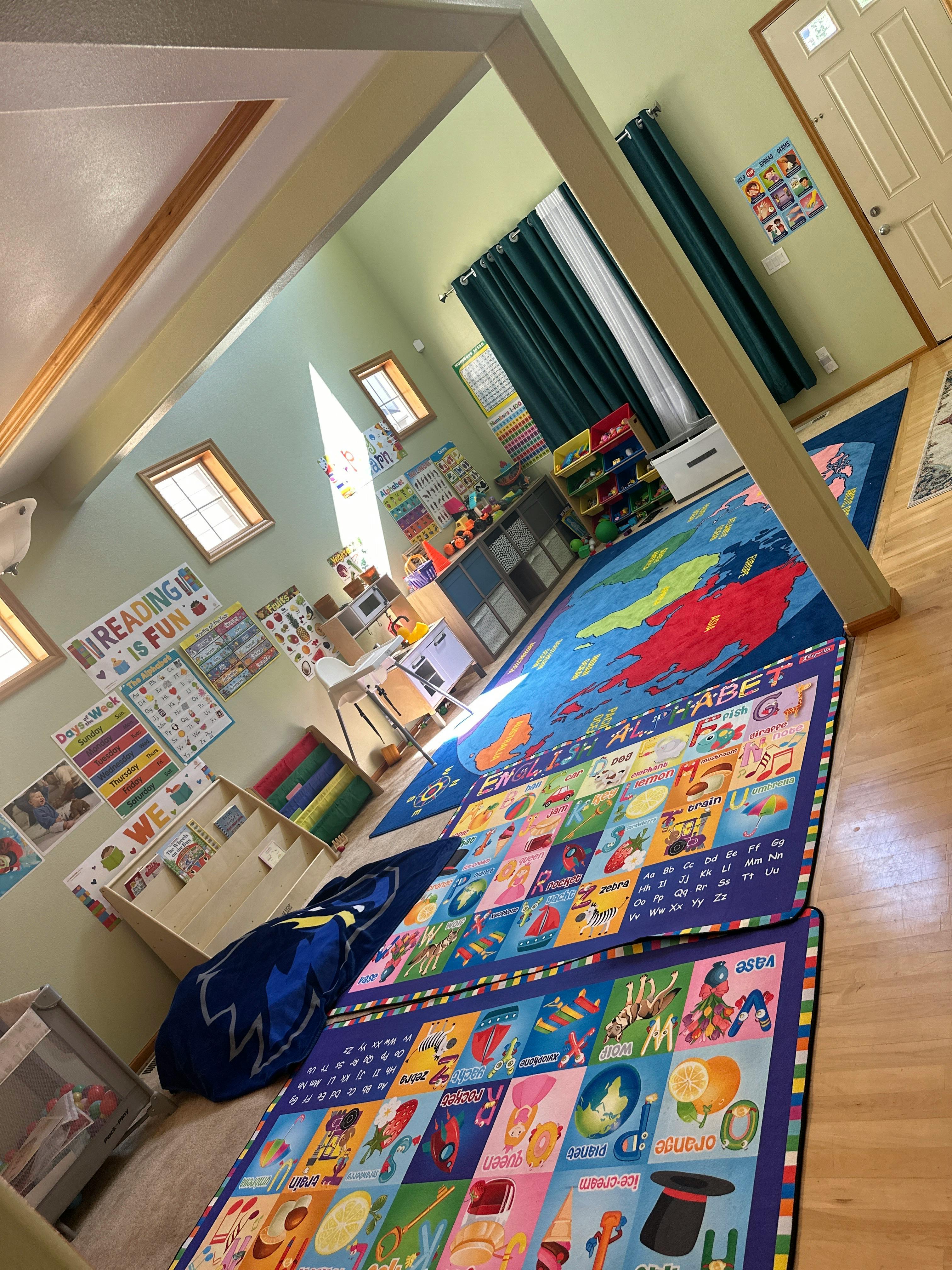 Classroom with colorful rugs on the floor and learning materials on the walls