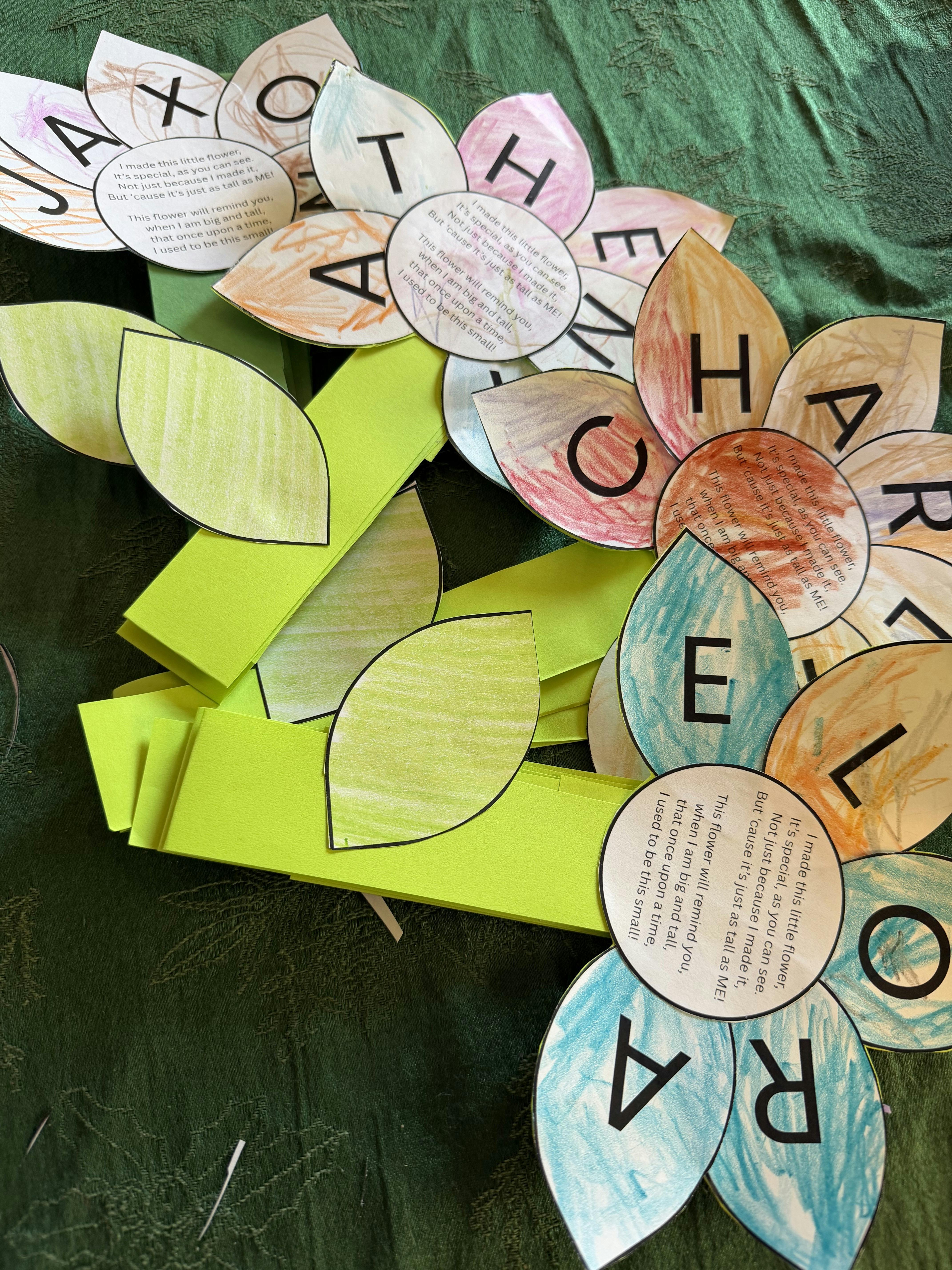 Paper flower crafts with letters and poems on a green cloth background