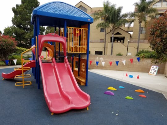 Playground structure with slides on blue rubberized ground
