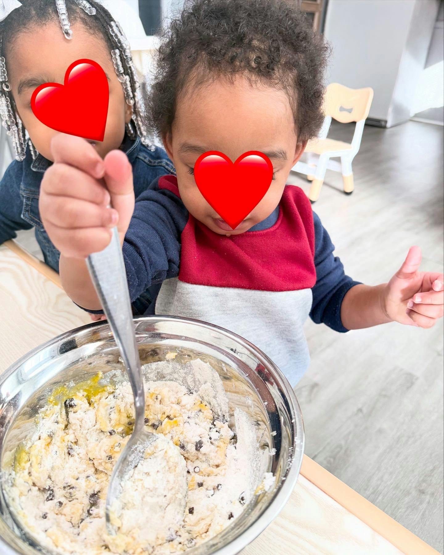 Two children mixing ingredients in a bowl with a spoon