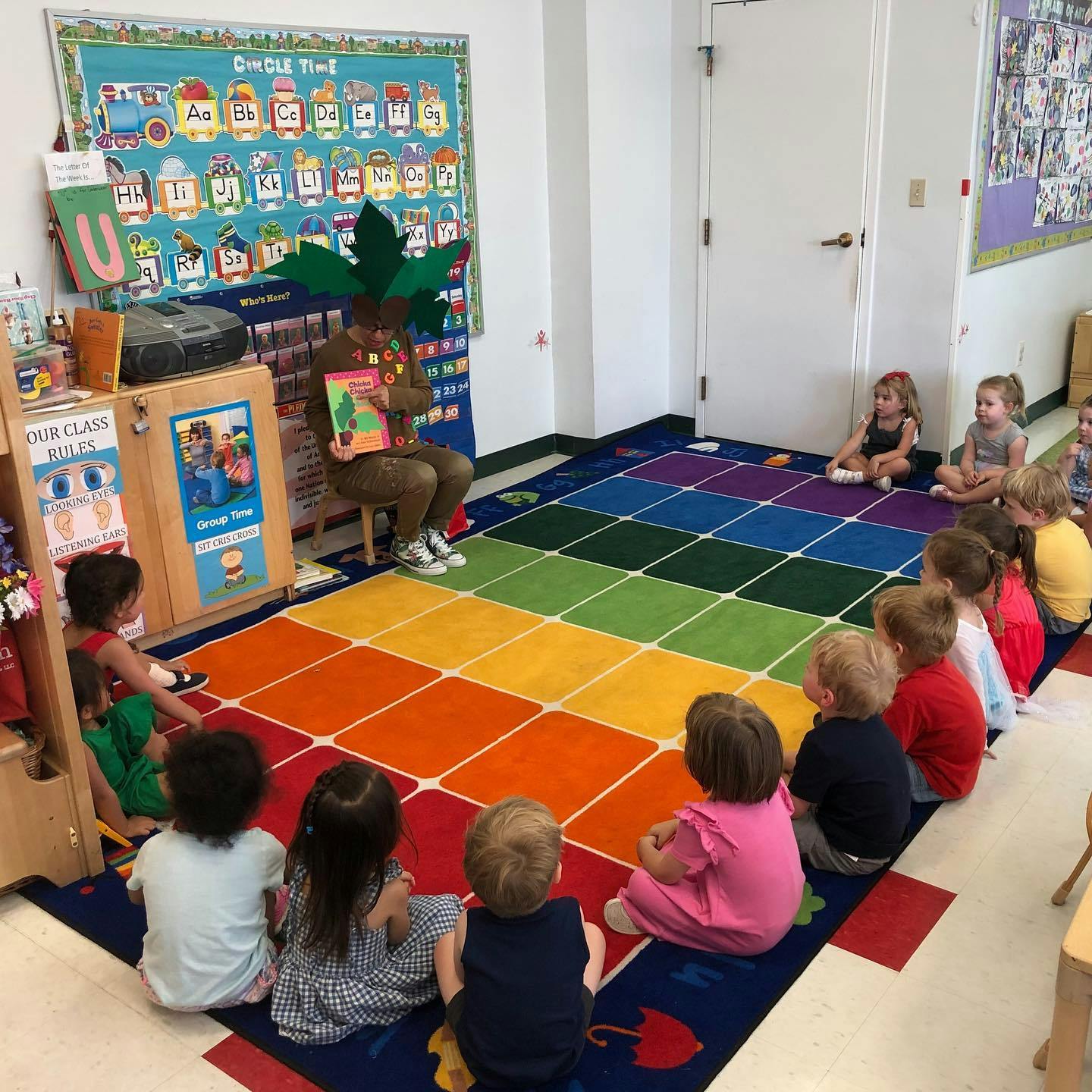 Person reading a book to children in a classroom