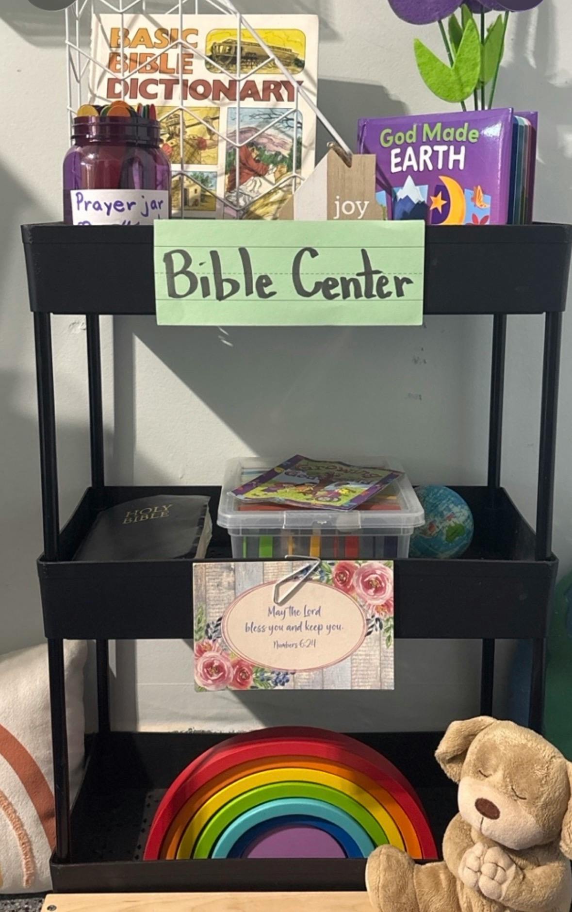 A multi-tiered cart labeled Bible Center containing books and religious items