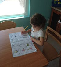 Child looking at an open book on a table