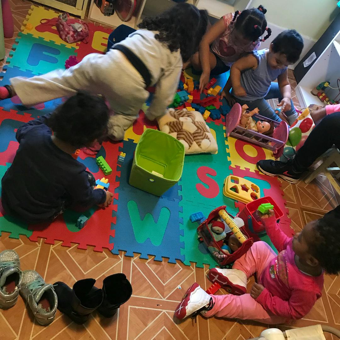 Children playing with toys on a colorful mat