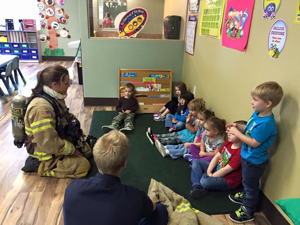Firefighter in uniform talking to children in a classroom