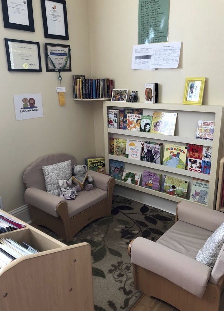 Children's reading nook with two small chairs and a bookshelf filled with books