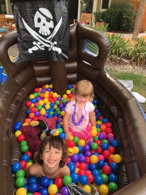 Two children in a pirate ship ball pit
