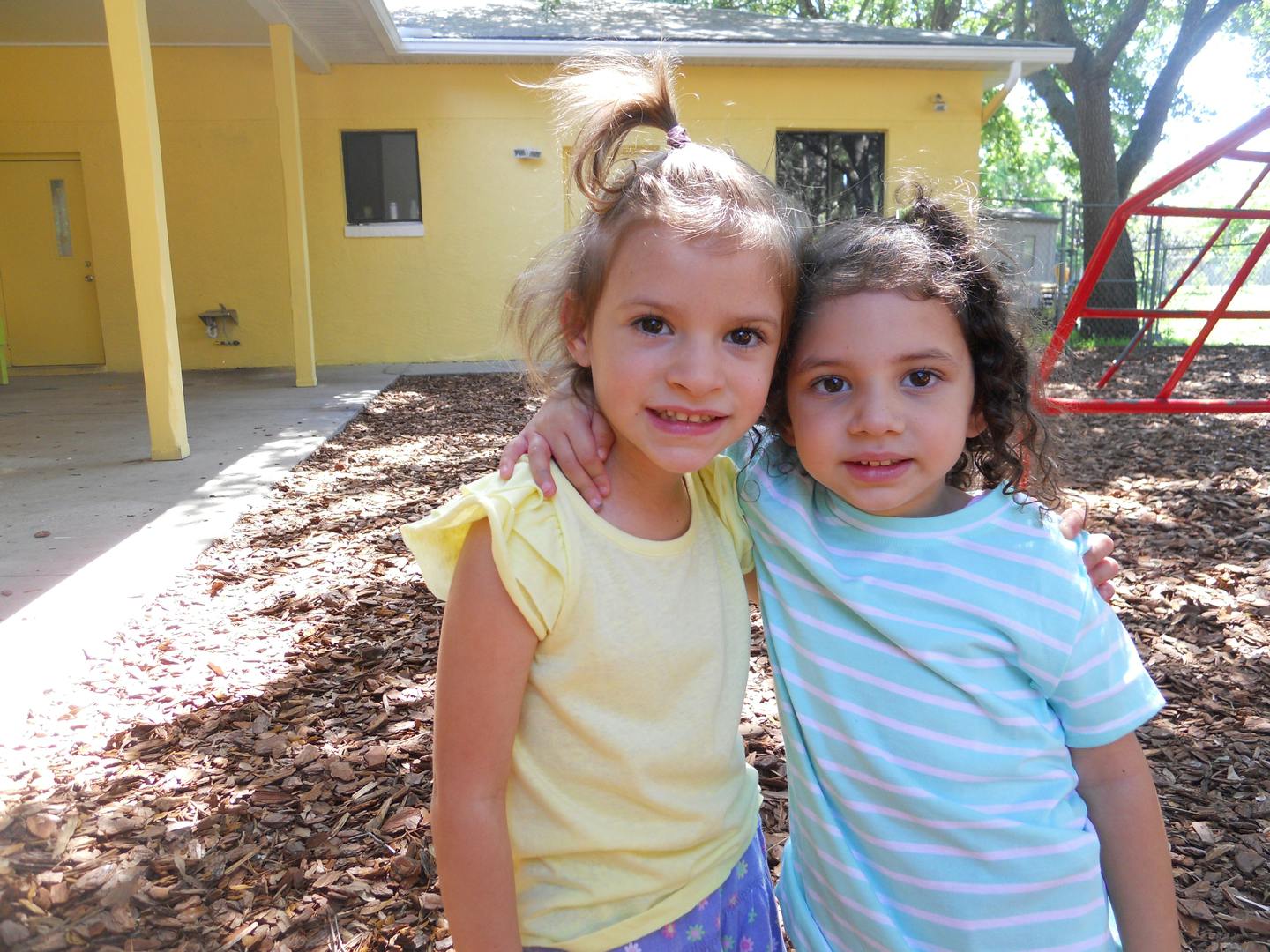 Two children standing with arms around each other