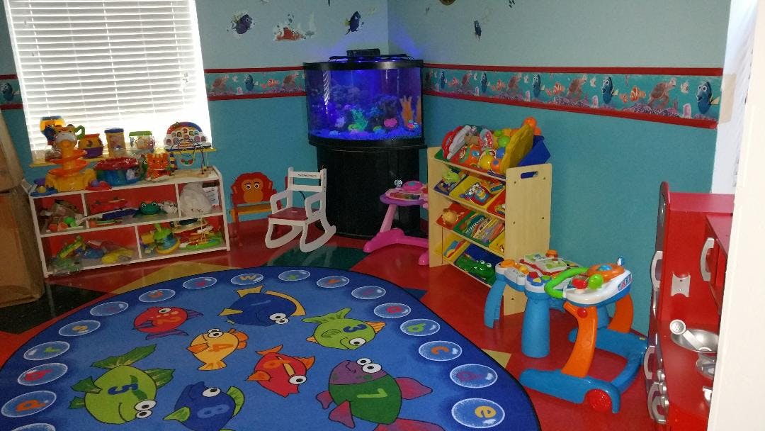 Playroom with a fish-themed rug, toy shelves, and an aquarium