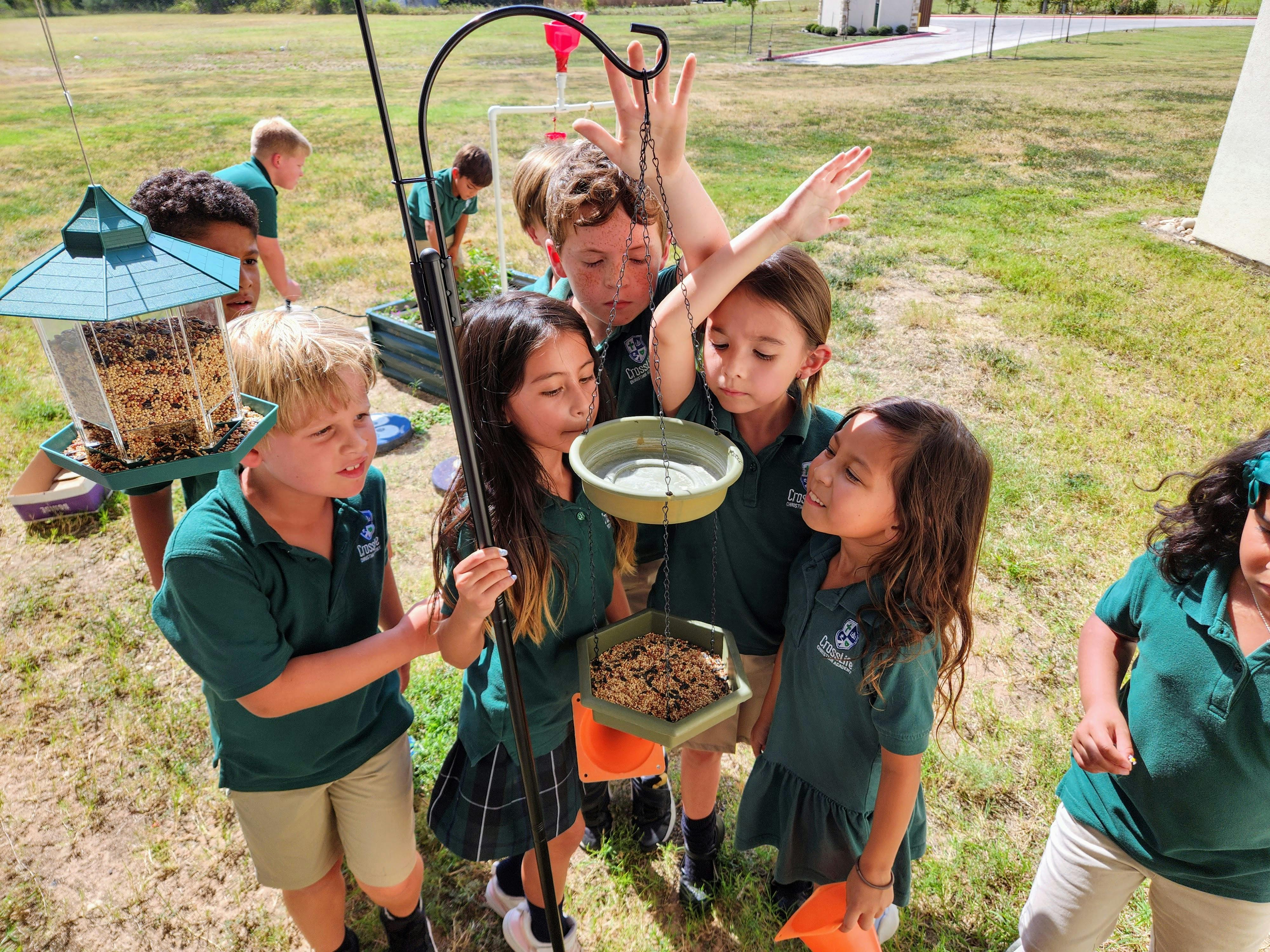 Children filling bird feeders with seeds