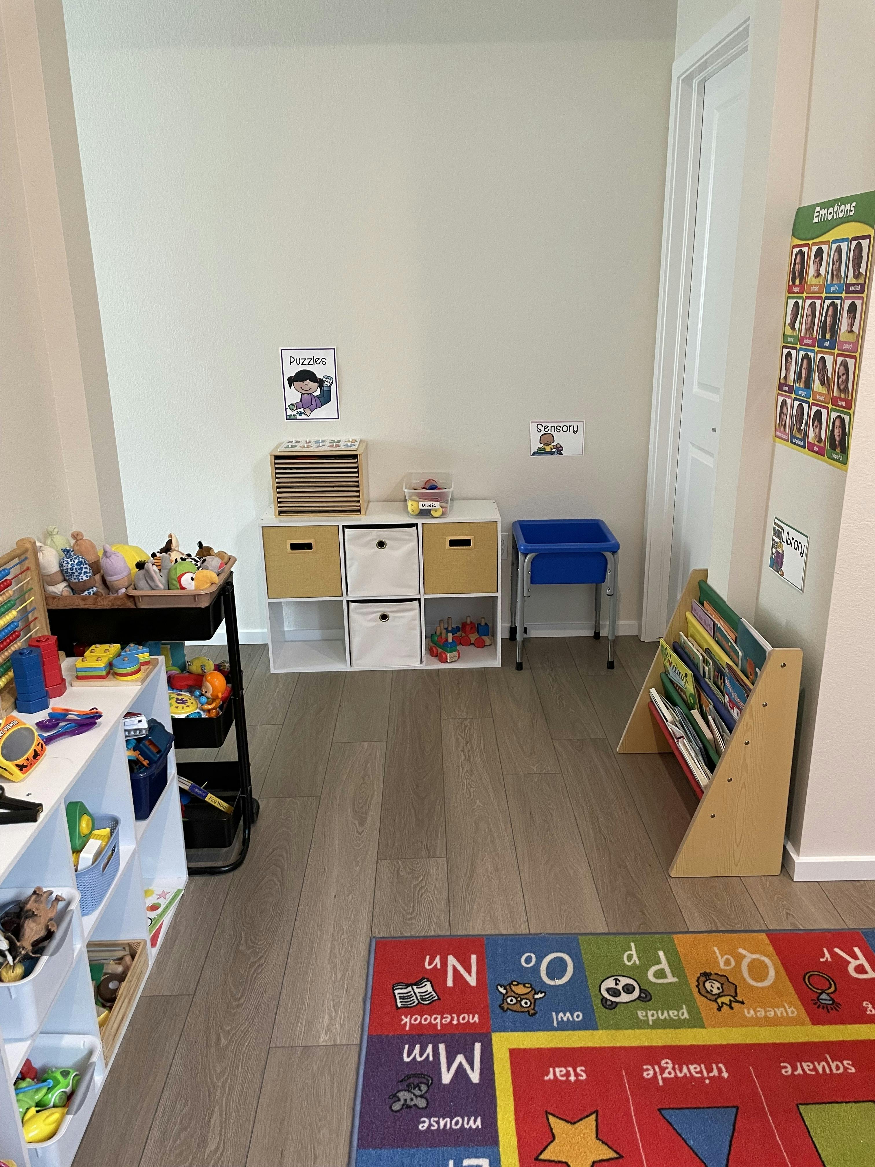 Classroom with storage shelves, a book display, and an alphabet rug
