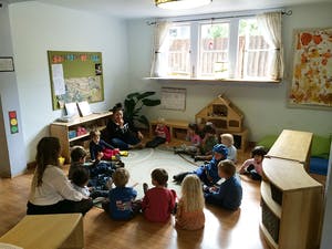 Adults and children sitting in a circle in a classroom