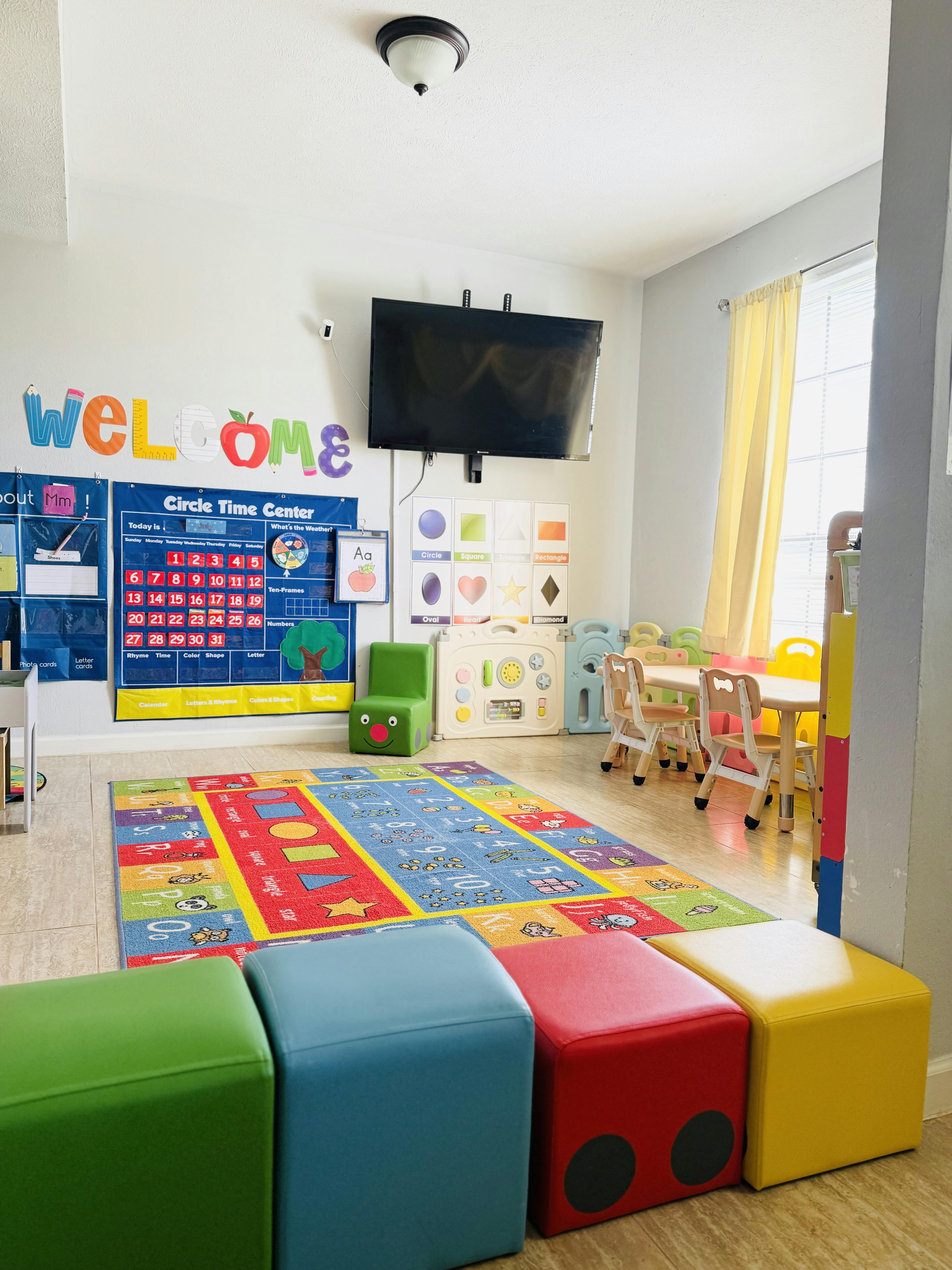 Classroom with colorful rug, small tables and chairs, and wall decorations