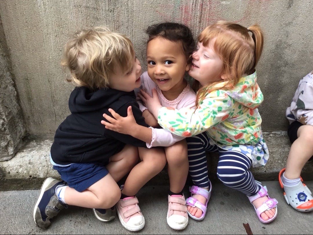 Three children hugging each other