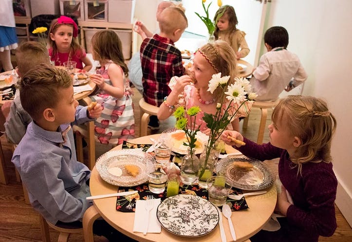 Children sitting around a table eating and eating