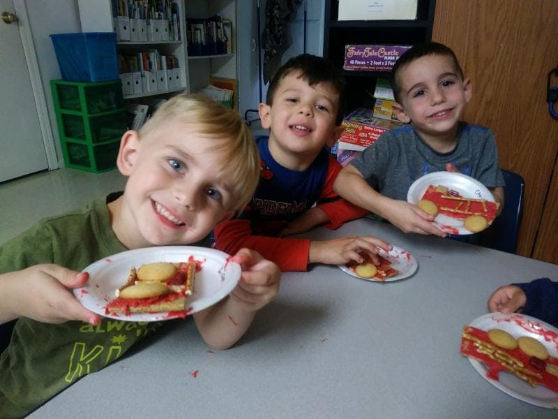 Three children holding plates with food on them