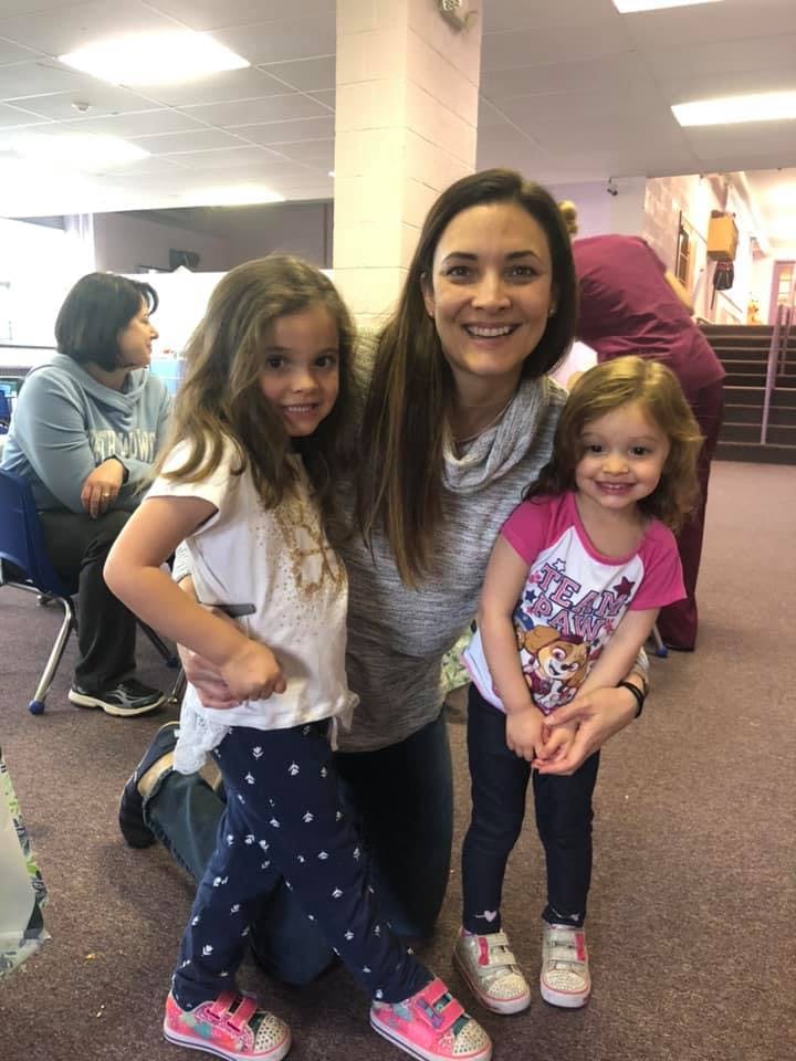 Person kneeling with two children
