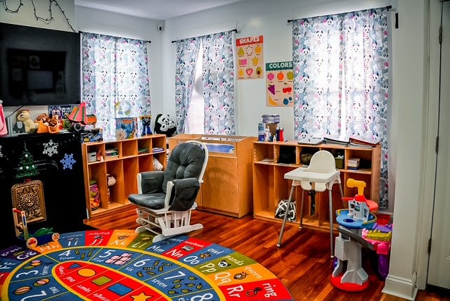 Child's room with a crib, rocking chair, and colorful rug
