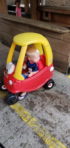 Child in a red and yellow toy car