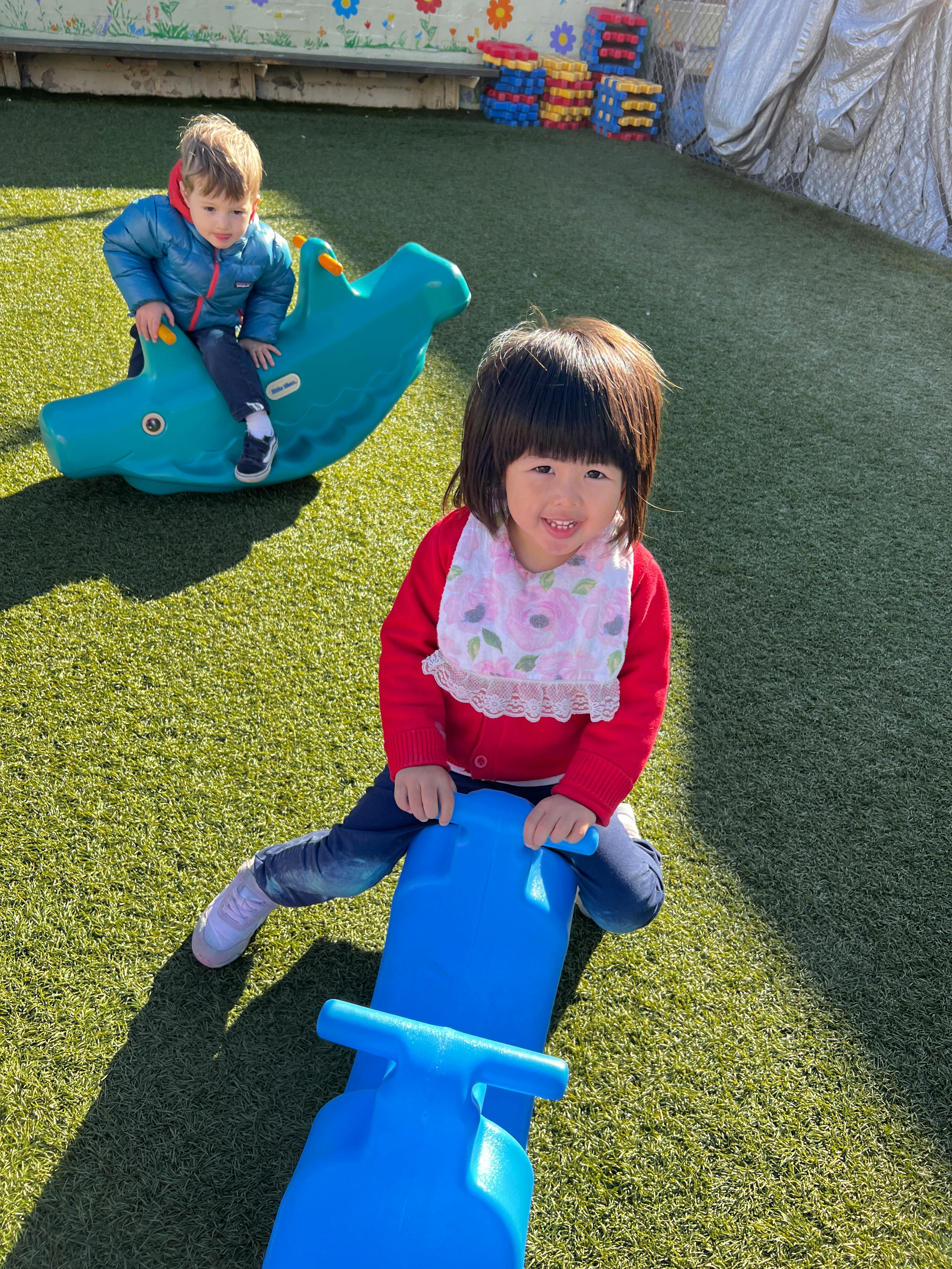 Two children on spring riders on artificial grass