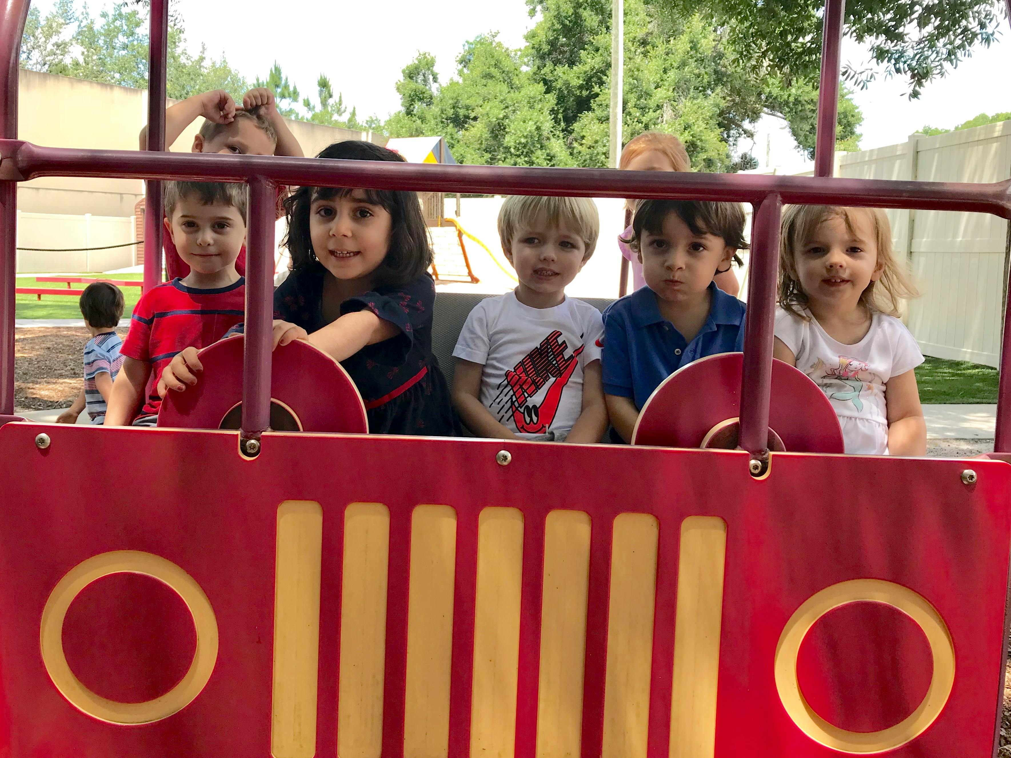 Five children in a red play structure
