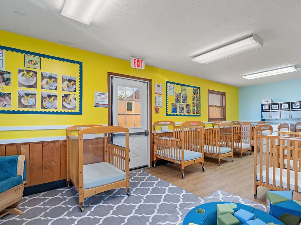 Cribs in a brightly lit daycare classroom