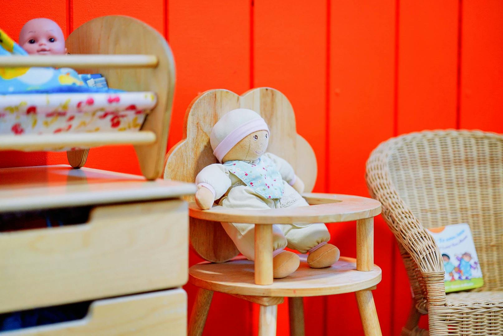 Dolls in a wooden high chair and crib