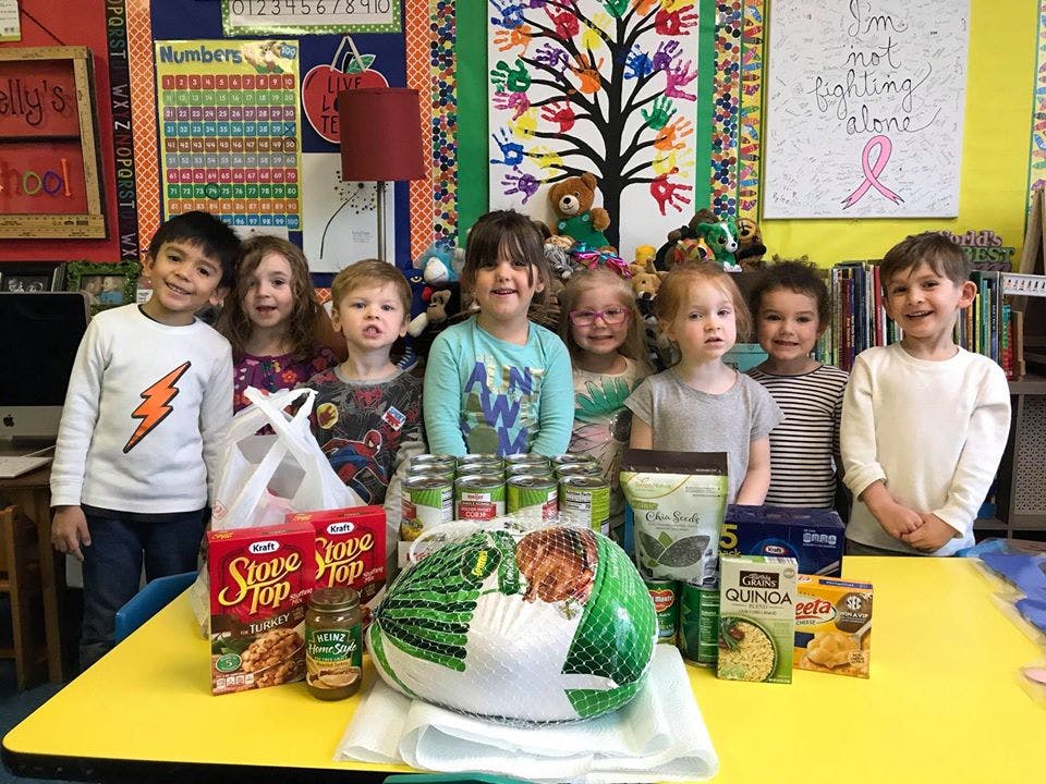 Group of children standing behind a table with food donations