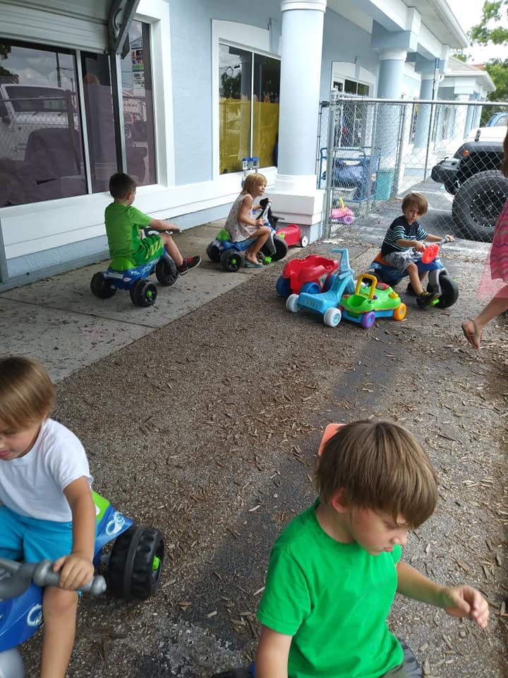 Children playing on ride-on toys outdoors