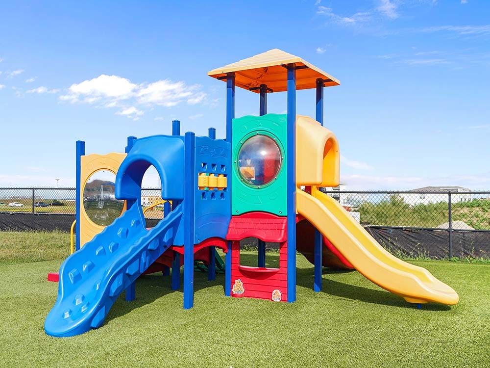 Colorful playground structure with slides on artificial grass