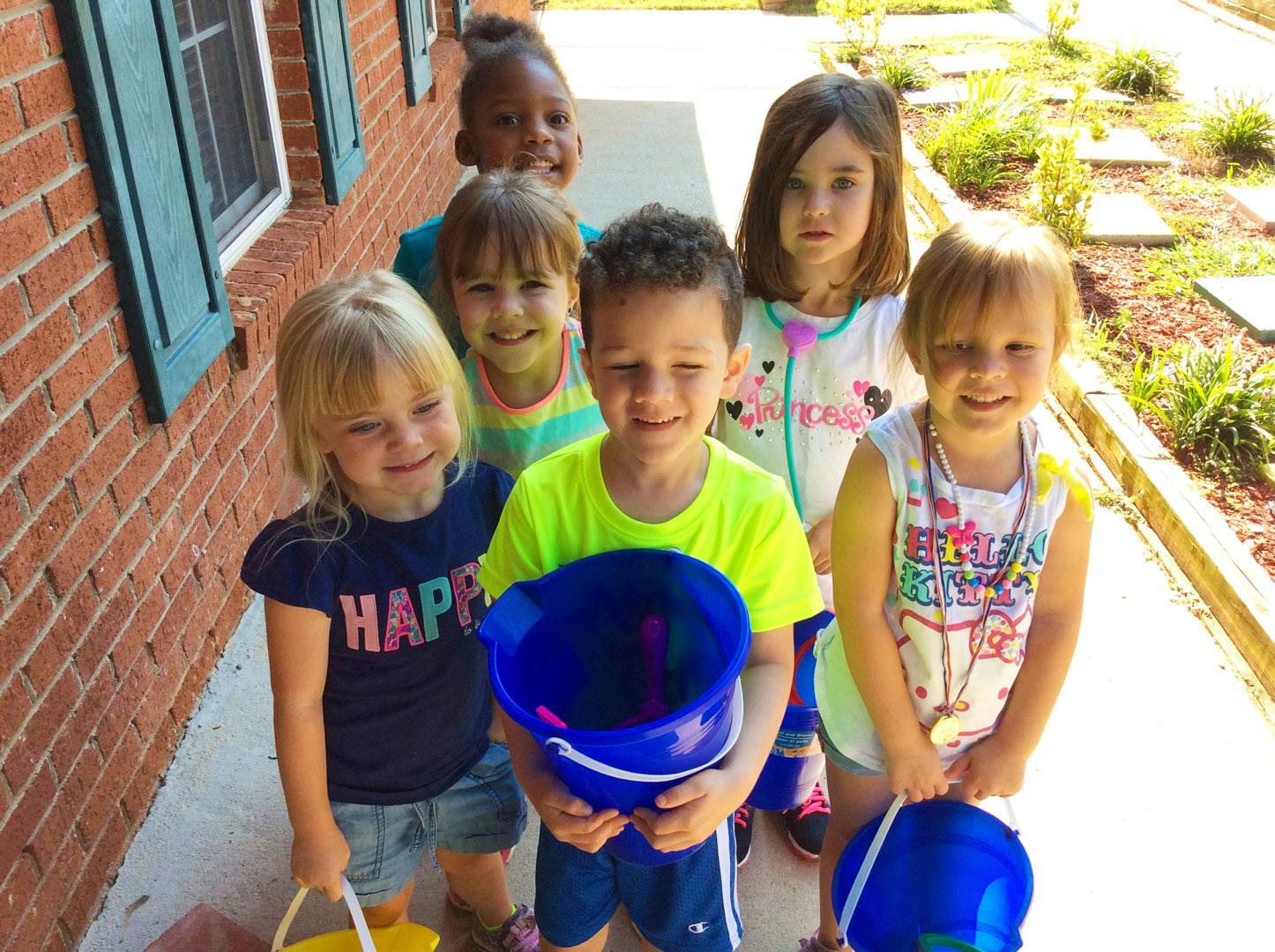 Group of children holding buckets