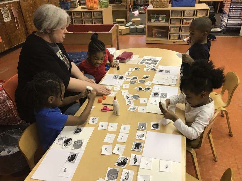 Adult and children at a table with cards and craft supplies