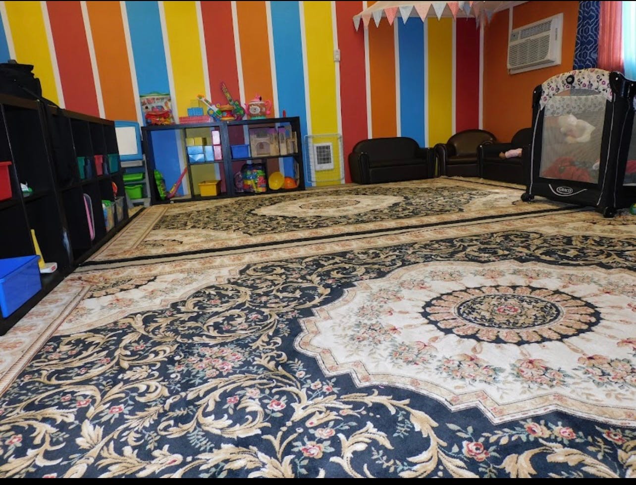 Room with patterned rugs, colorful striped walls, and a playpen