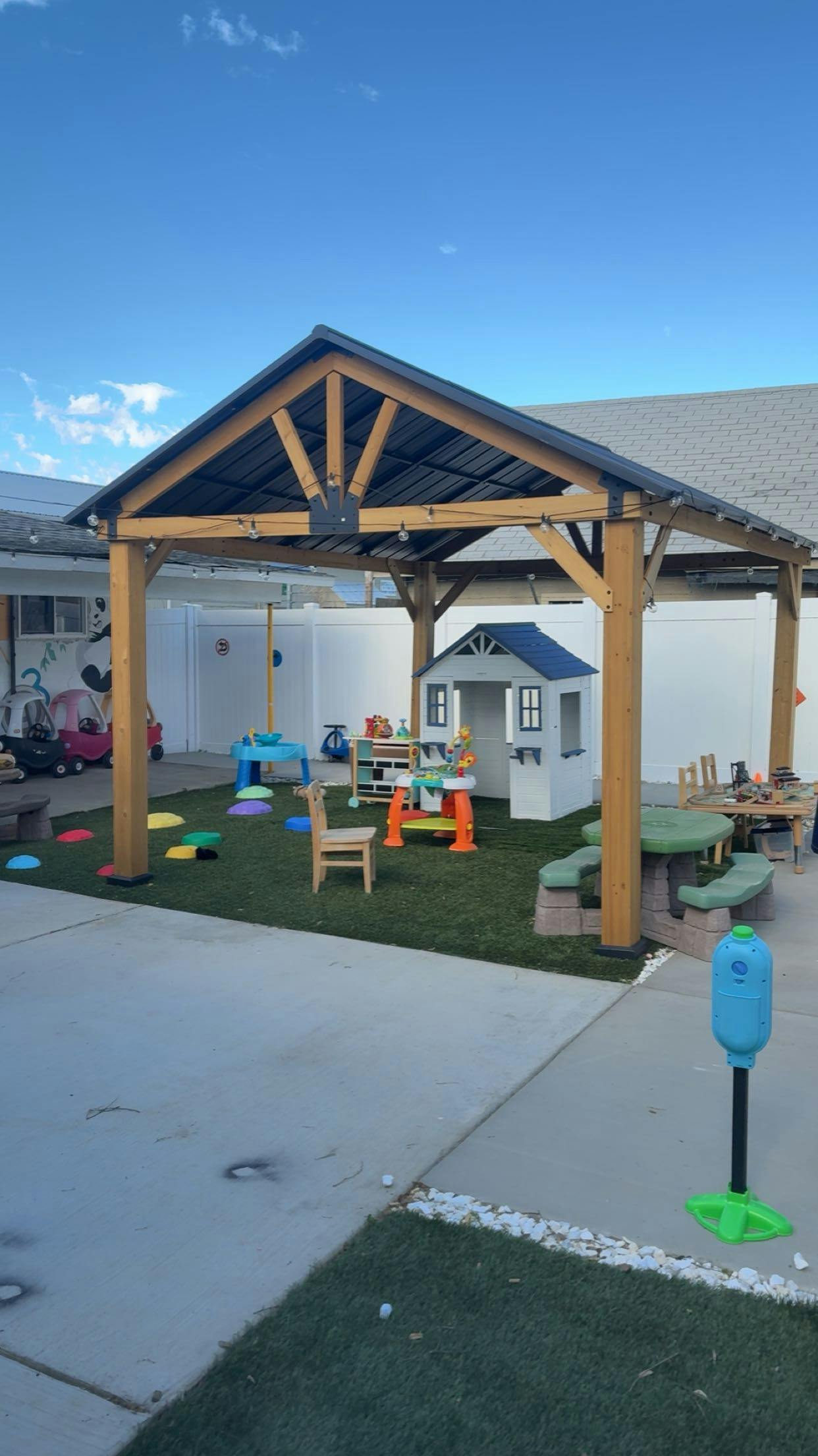 Outdoor play area for children under a wooden gazebo