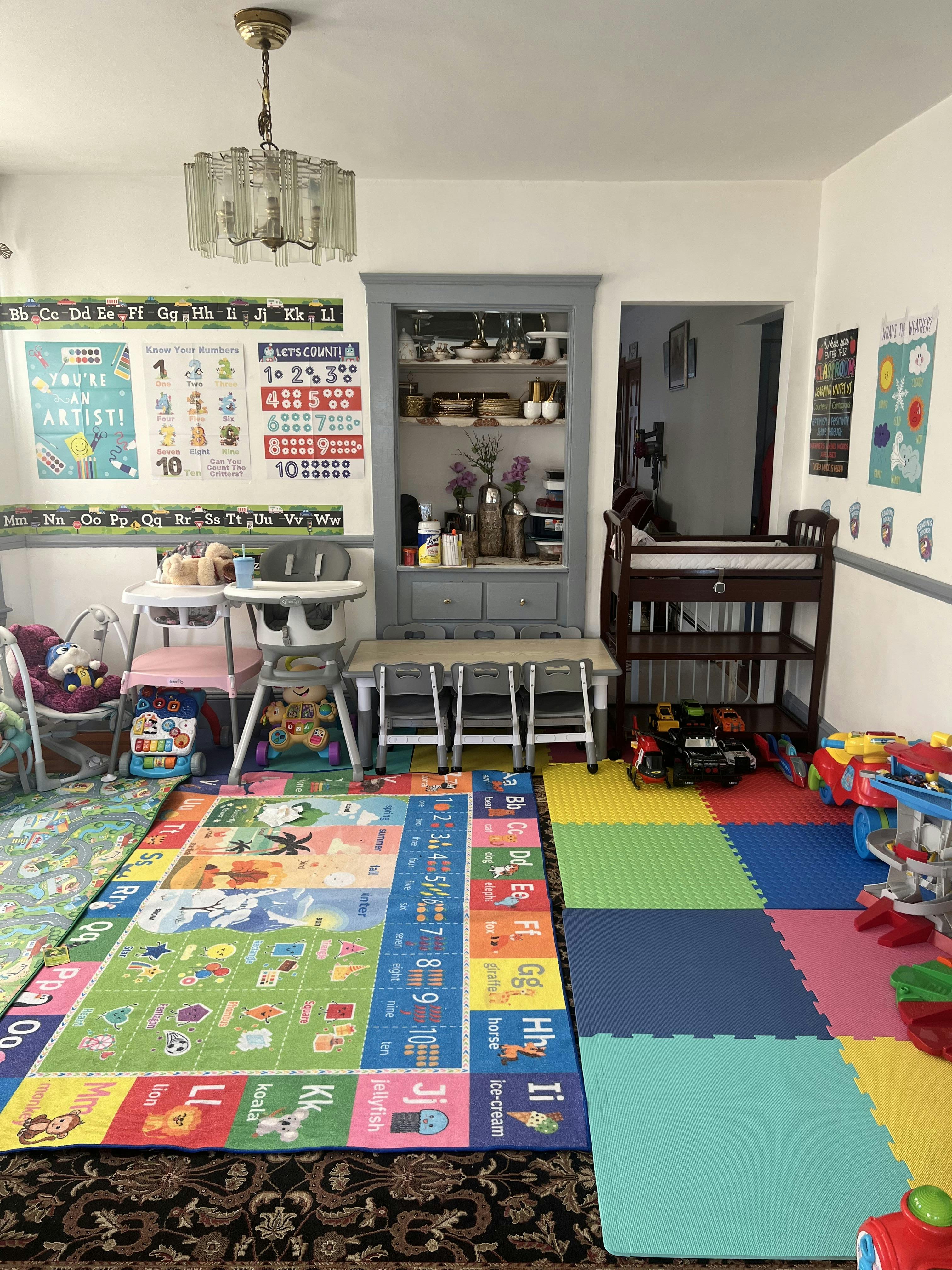 Child's play area with alphabet mats, high chairs, and toys