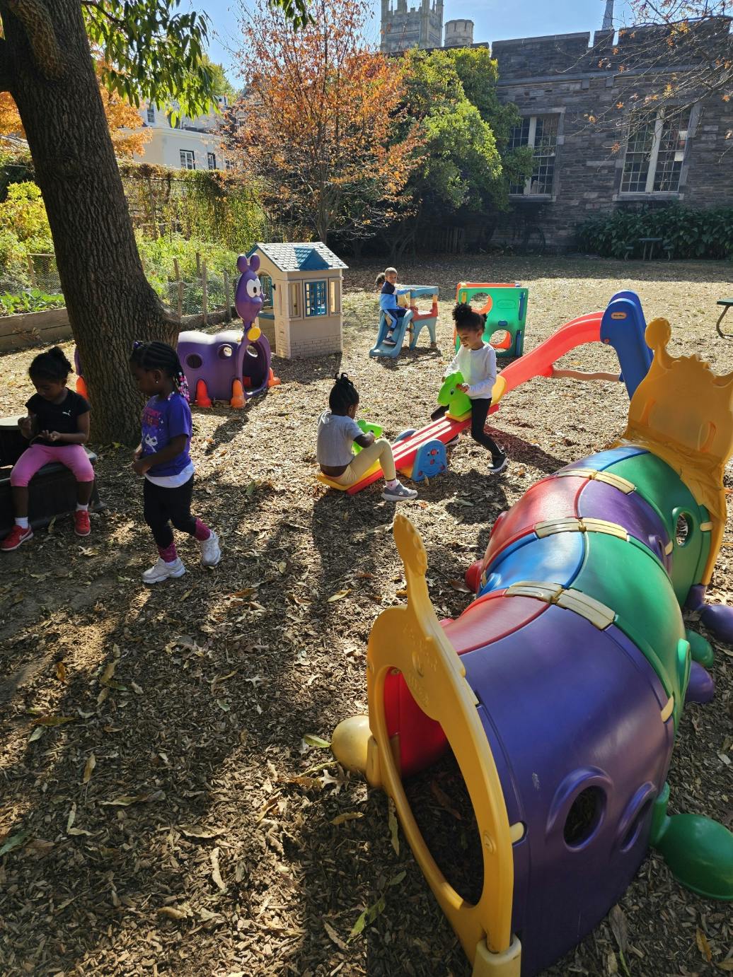 Children playing on a playground with various play structures
