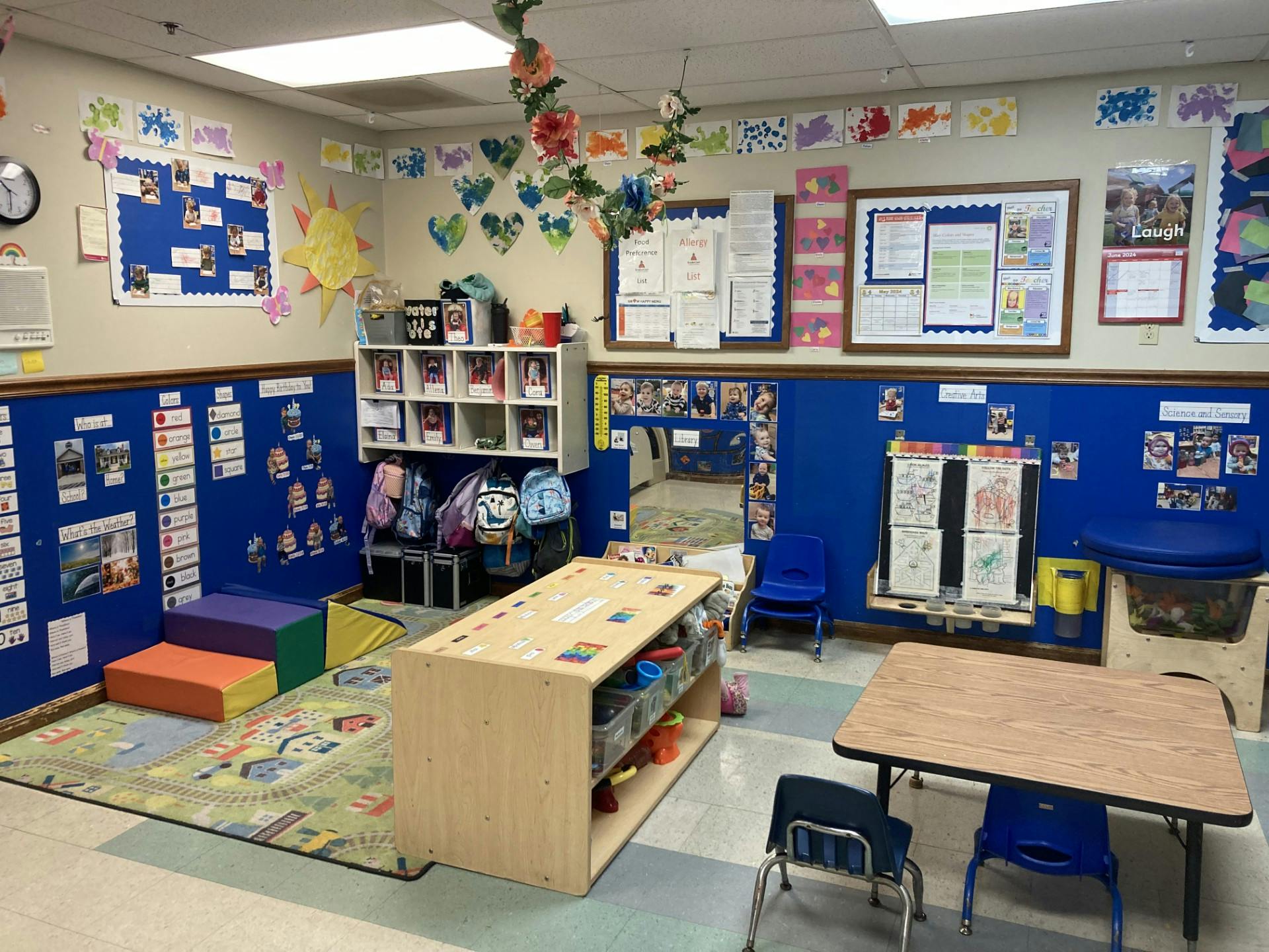 Colorful classroom with playmat, tables, and storage units